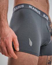 Nahaufnahme dunkelgraue Boxershort mit dunkelgrauem Bund und dem Schriftzug IKARUS, sowie eingesticktem Logo auf dem Bein